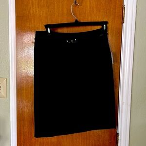 Black lined skit with slim belt. Never worn new with tags. Kick pleat in back